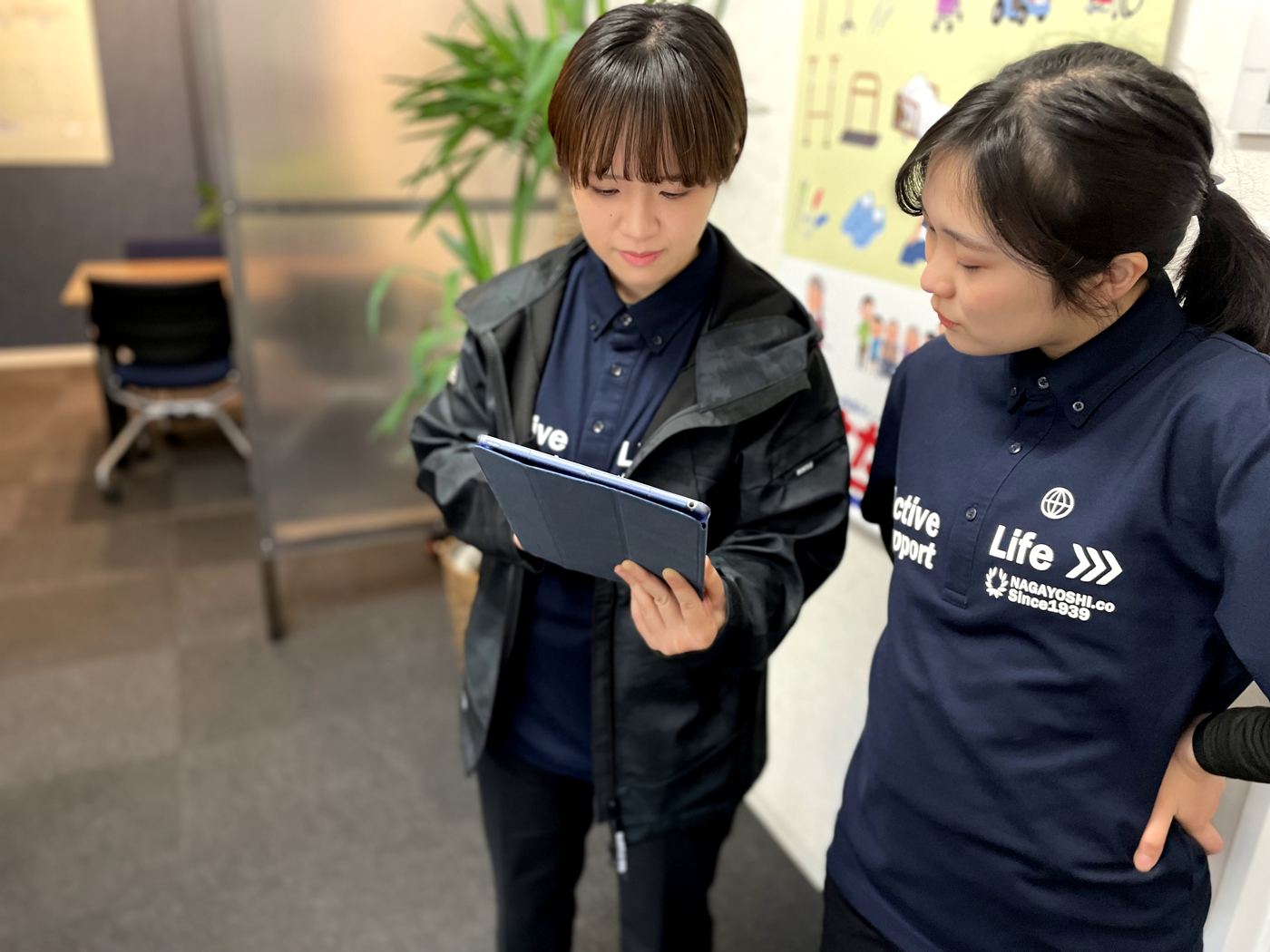 タブレットを見ながら打ち合わせる2人のスタッフ