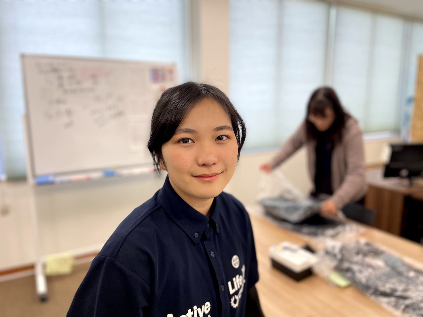 事務所で笑顔を見せるスタッフ
